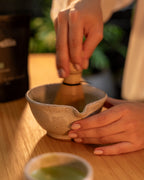 Preparo do matcha Jade: matcha sendo batido com batedor de bambu em tigela de cerâmica